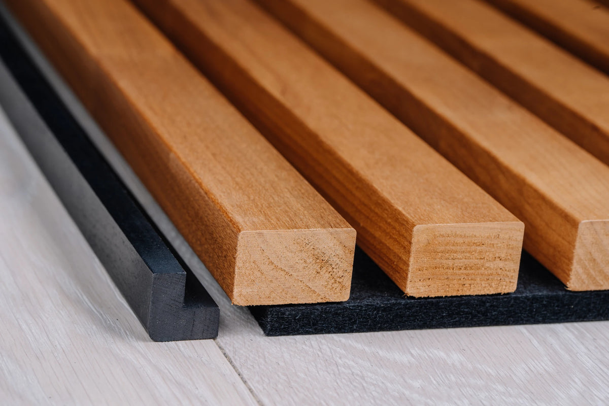 Black corner profile beside the edge of a thermo aspen slat panel on black felt