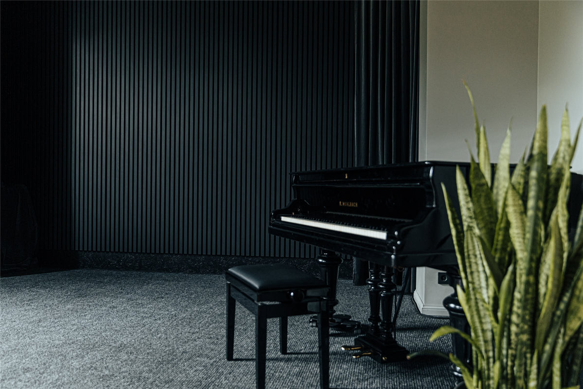 Music room with anthracite aspen slat acoustic walls and a piano