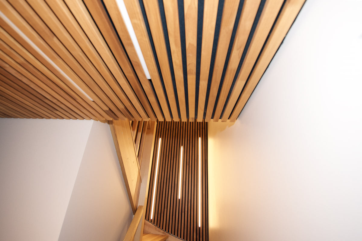 Thermo aspen slat ceiling and wall in a stairwell with warm light