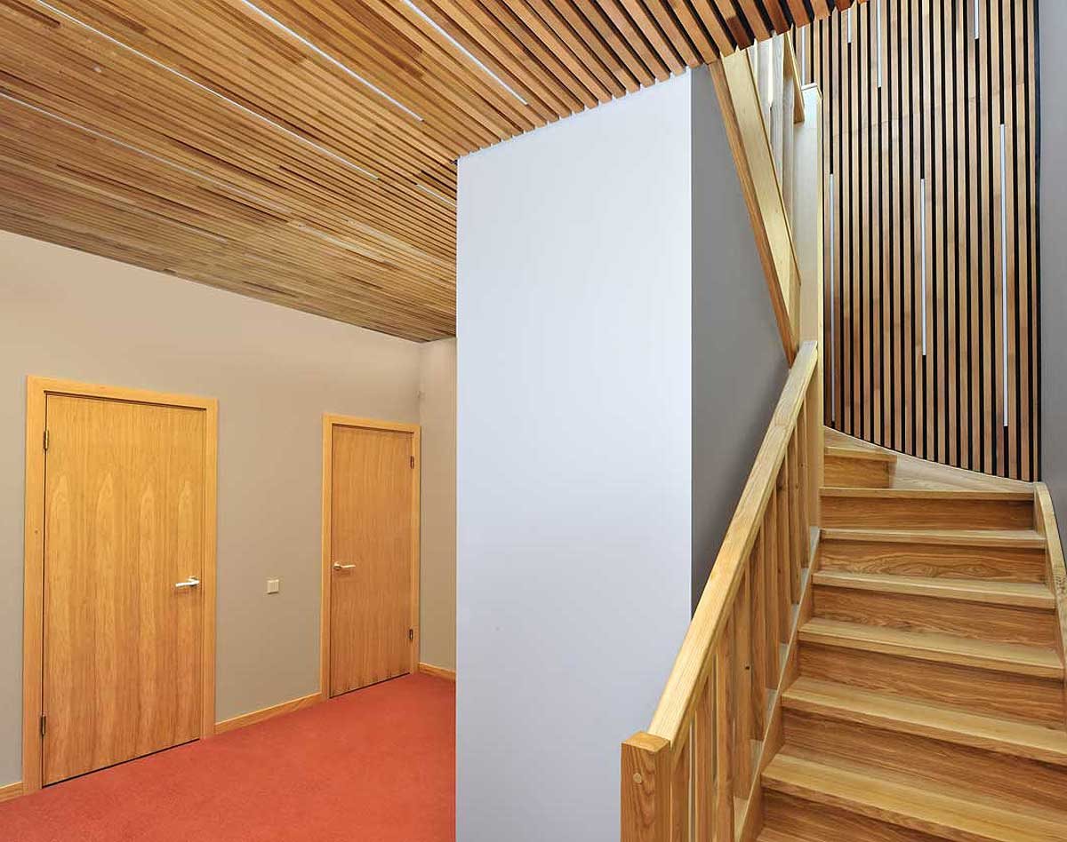 Staircase and ceiling clad in thermo aspen slat acoustic panels