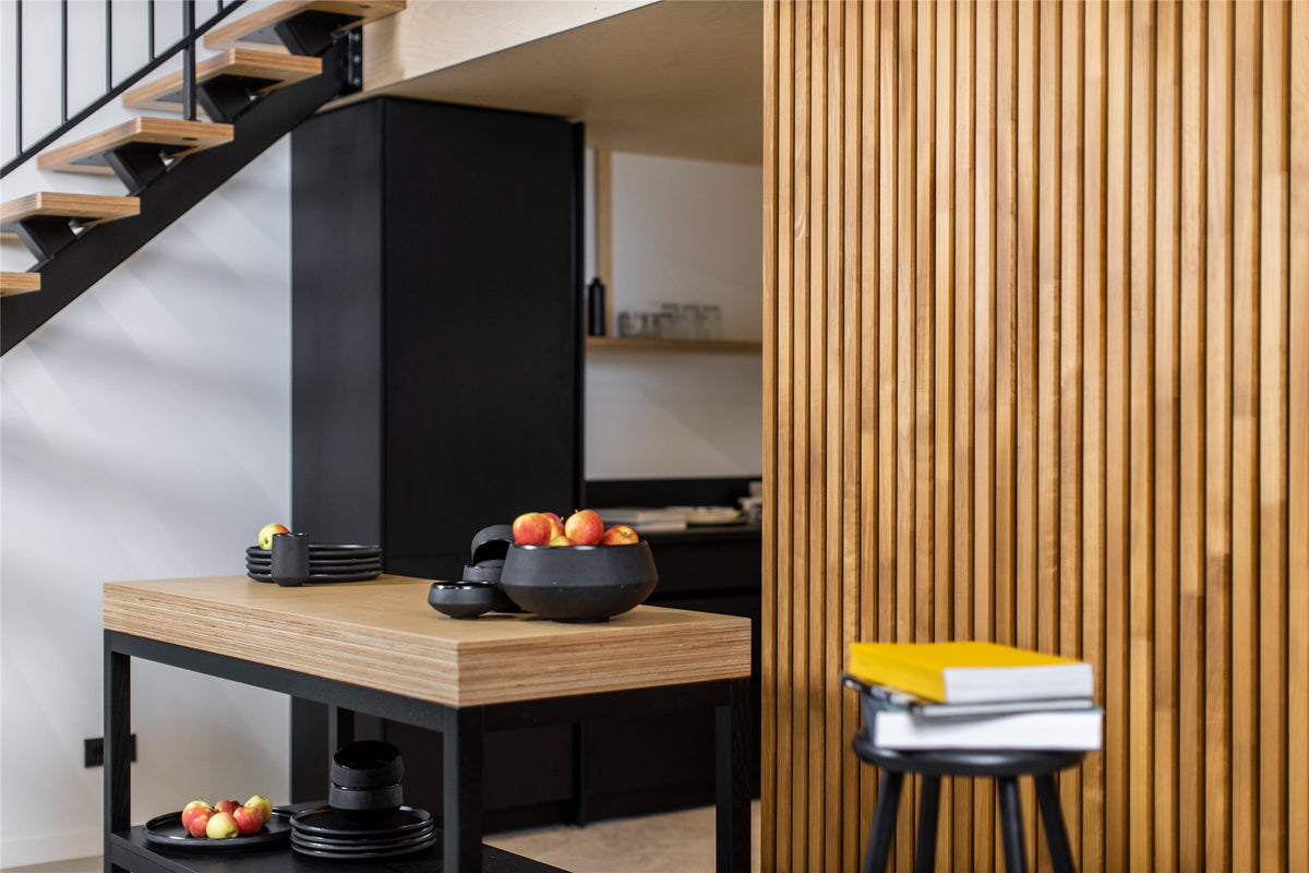 Kitchen and staircase beside a wall of thermo aspen slat acoustic panels