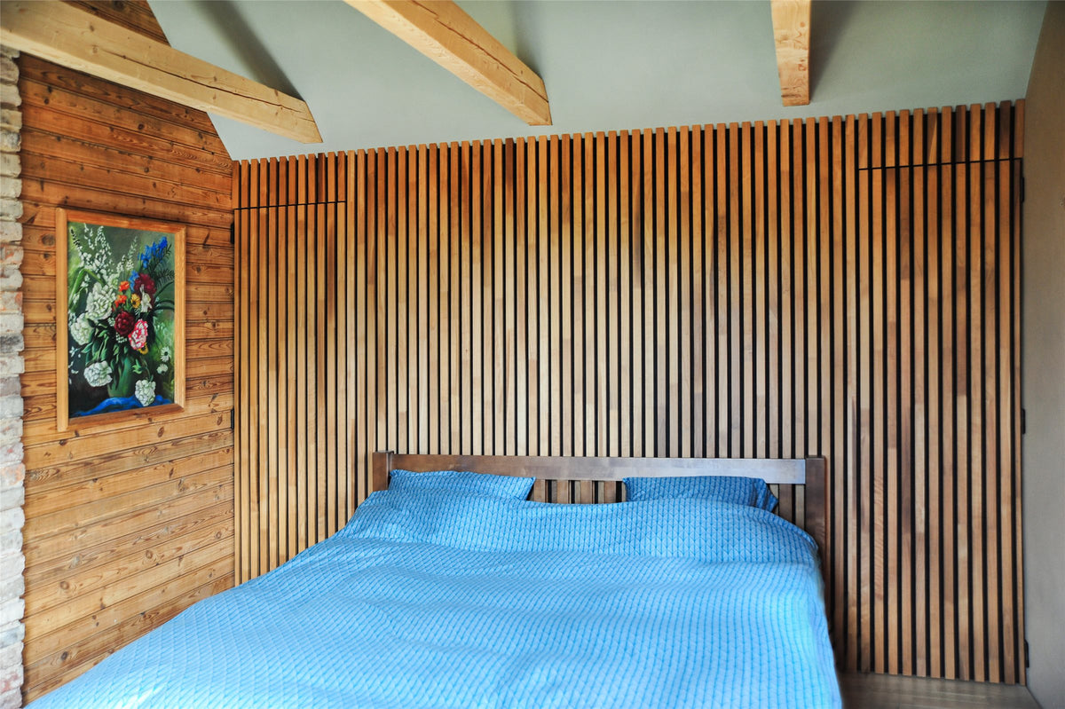 Bedroom with a thermo aspen slat accent wall behind the bed