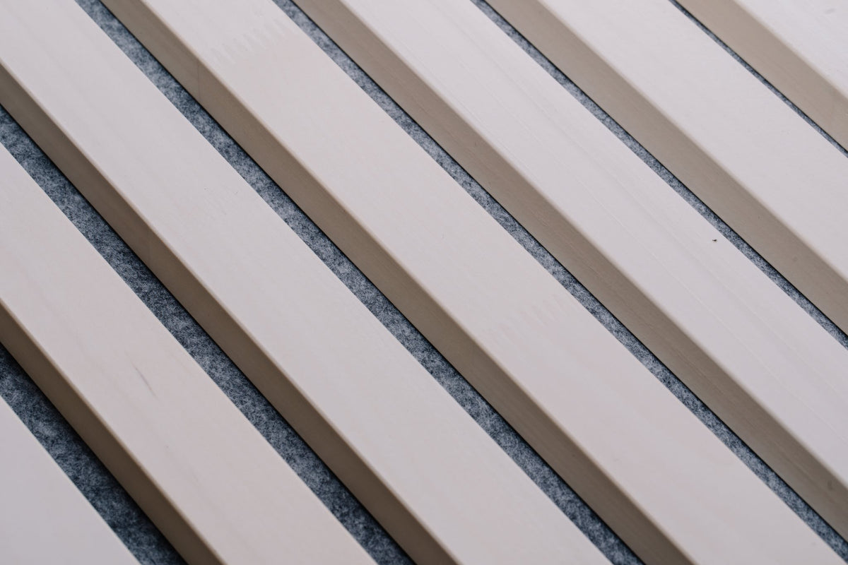 Close-up of white aspen slats over grey PET felt at a diagonal angle