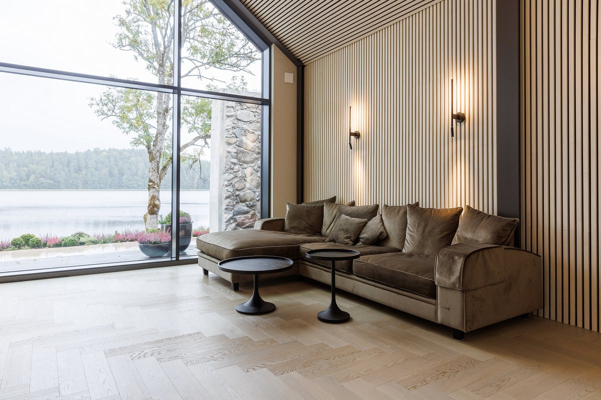 Lounge with a white slat acoustic wall behind a corner sofa and a view of the lake
