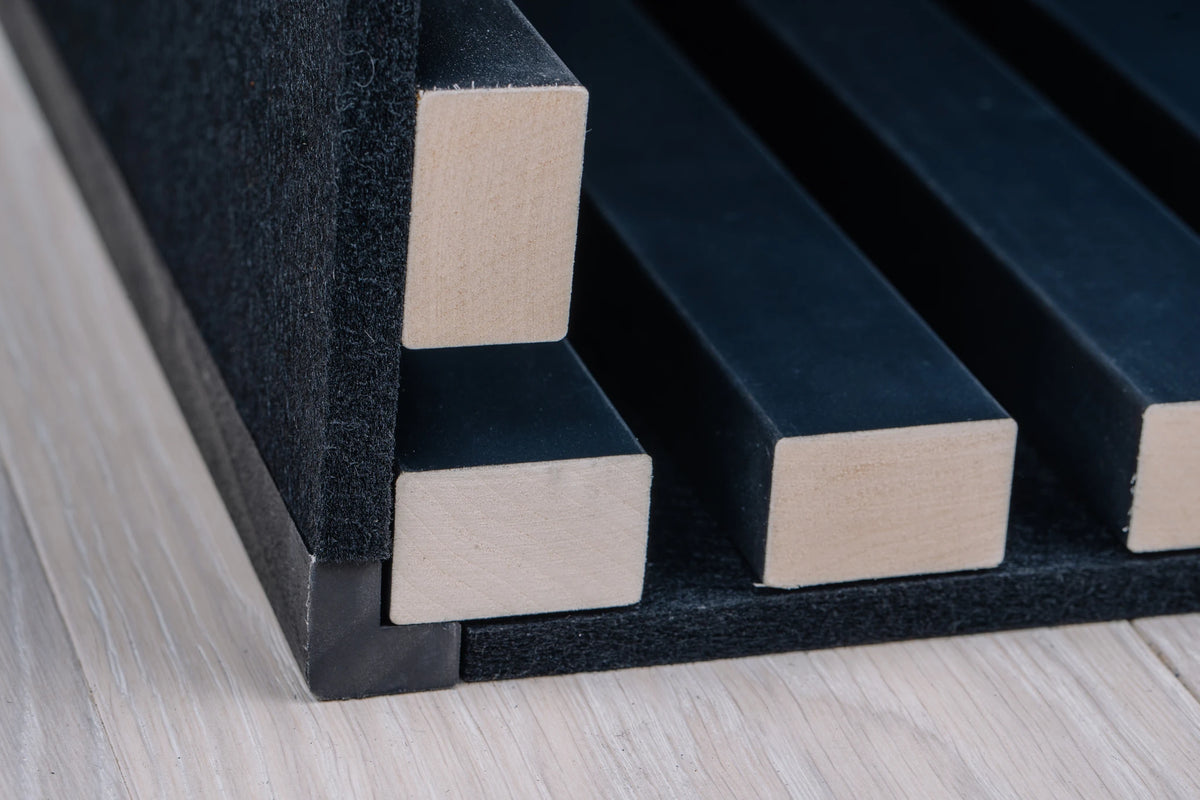 Black corner profile in the inside corner of anthracite aspen slat panels on black felt