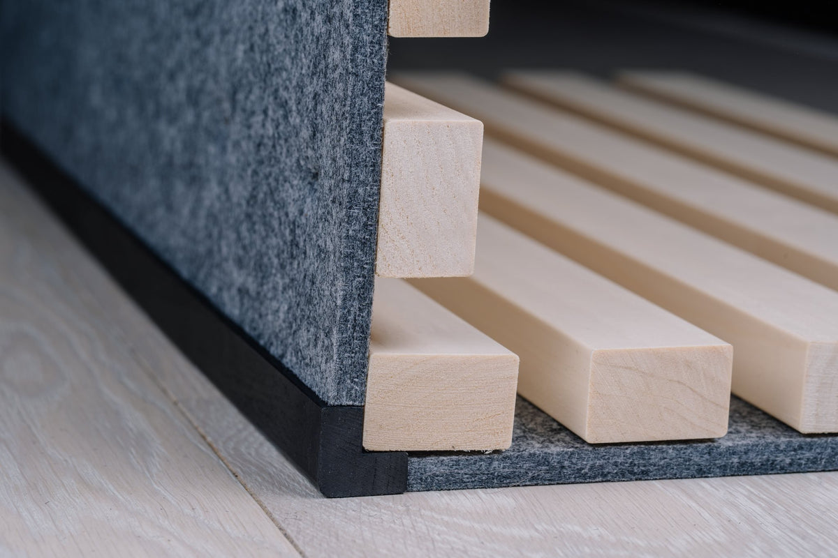 White aspen slats on grey felt meeting at a corner with a black corner profile