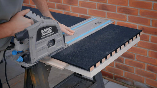 Cutting a slat panel with a circular saw on a guide rail and a black cutting plate underneath