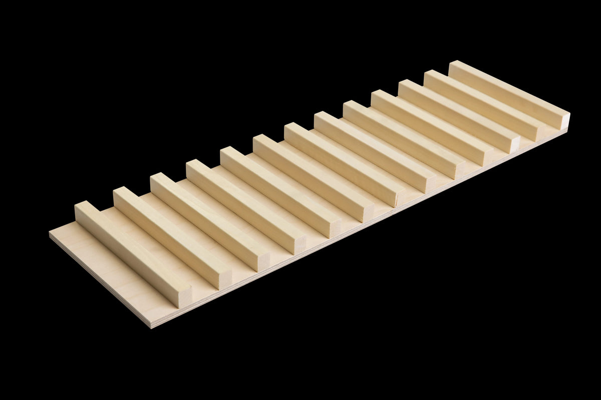 Cutting plate with its raised slats facing up, three-quarter view on a black background
