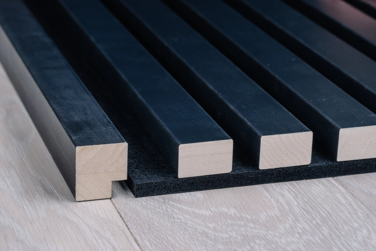 Close-up of the anthracite end moulding profile next to anthracite aspen slats on black felt