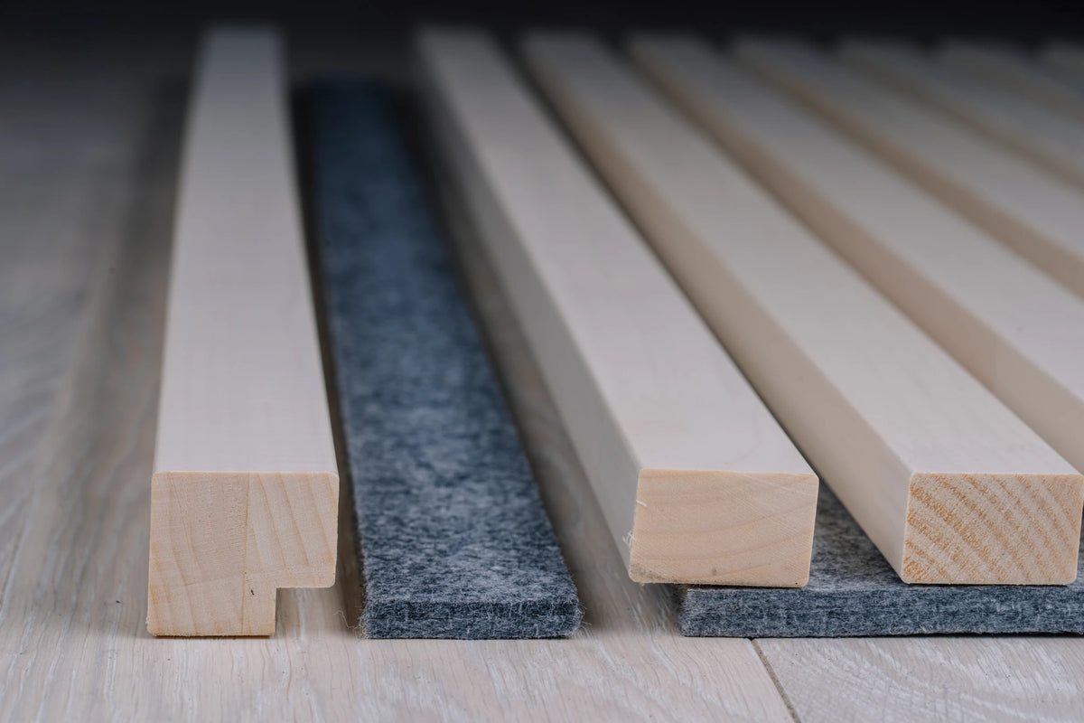 White end moulding beside a grey felt end strip and white slats on grey felt