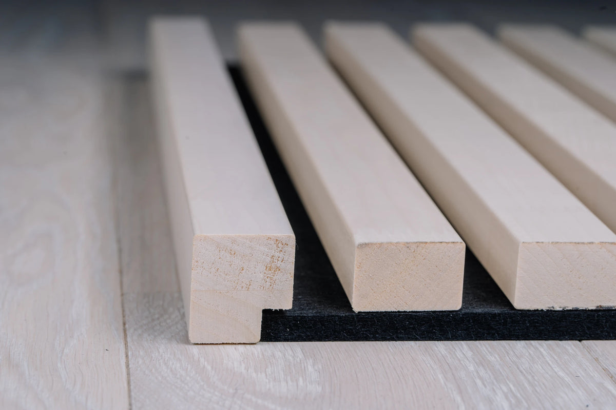 White end moulding profile at the end of white aspen slats on black felt