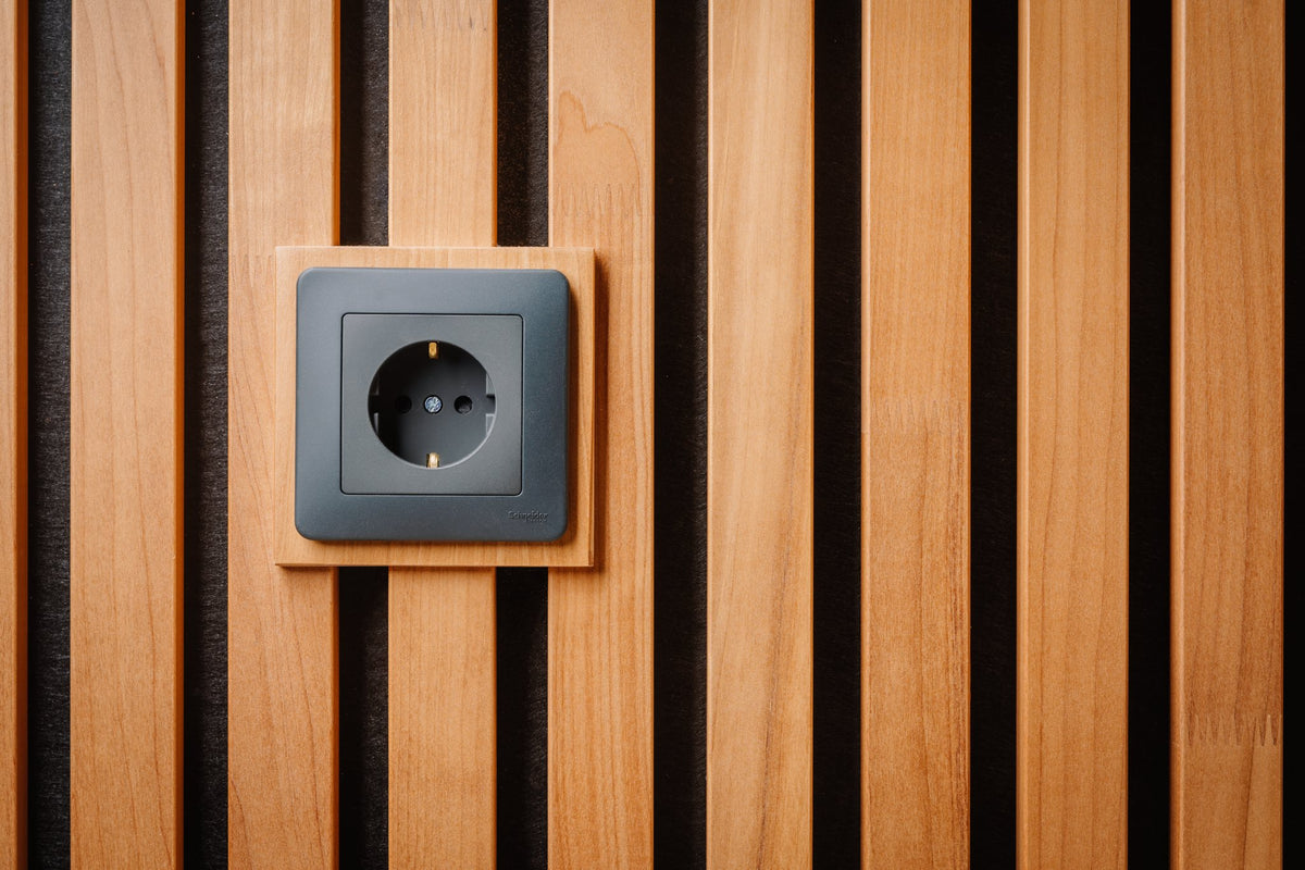 Thermo aspen plate around a grey wall socket set into a thermo slat panel